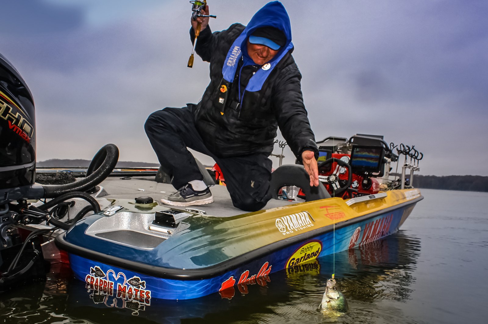 Dan Dannenmueller (Crappie Dan) reaches for a crappie caught on Lake Washington using a Bobby Garland Bait and his B'n'M Pole. 